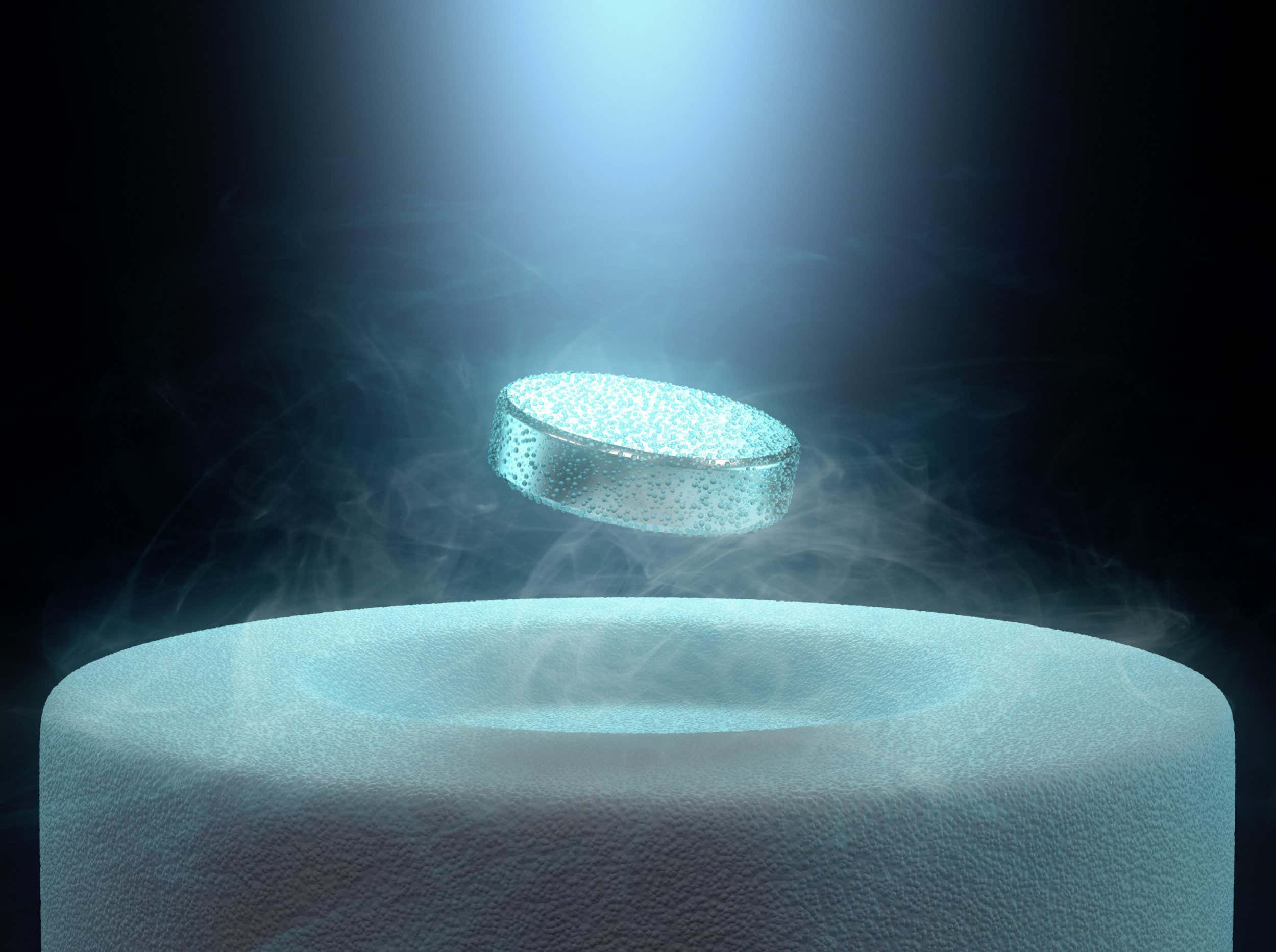 E8X75D Image concept of magnetic levitating above a high-temperature superconductor, cooled with liquid nitrogen.