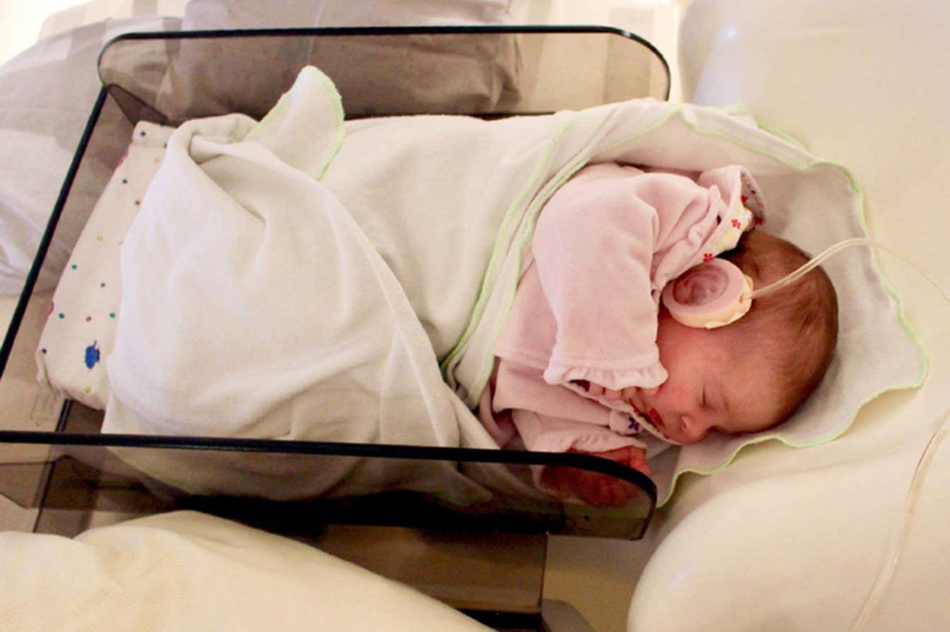 A baby in the trial having its brain's electrical activity recorded while hearing sound stimuli